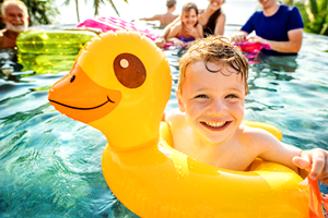 A boy in a rubber ring in a swimming pool.