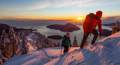 A pair of hikers scaling a snowy peak.