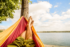 A man resting in a hammock attached to a tree.