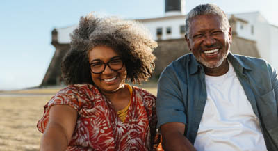 A mature couple sitting down for photo.