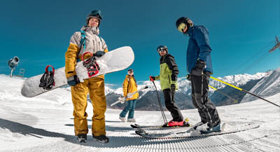 A group of people posing for a photo while enjoying skiing and snowboarding.