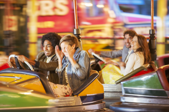 Young people enjoying dodgems ride at a fairground.