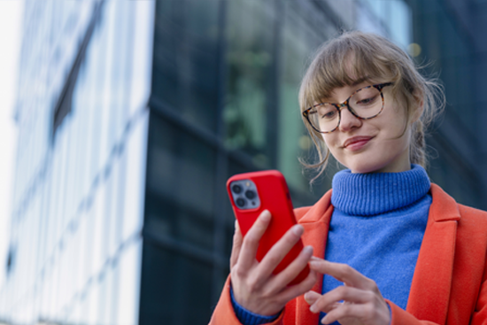 Young woman using smartphone in street.