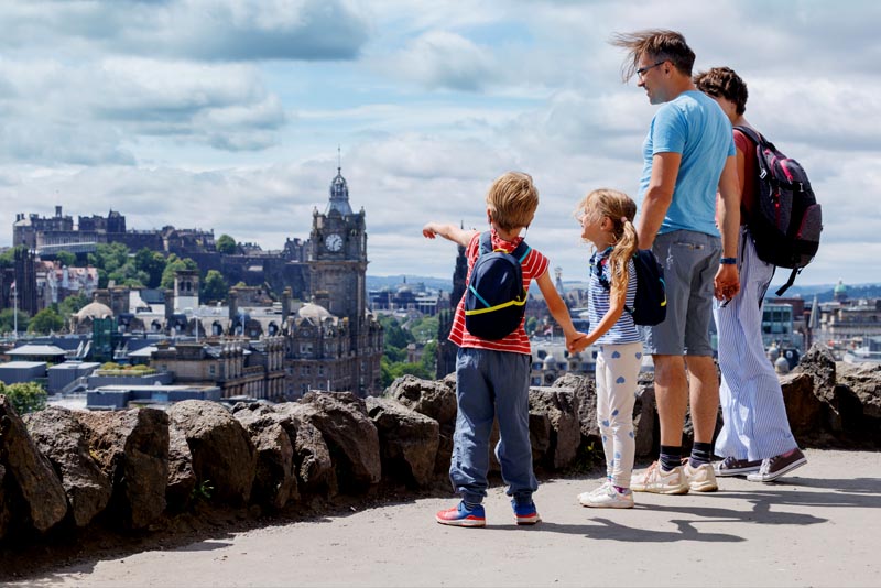 A family gazing out across the rooftops of Edinburgh, Scotland.