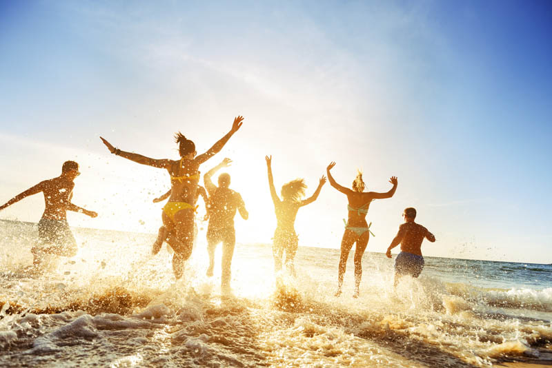 Image of a family playing on a beach at sunset.