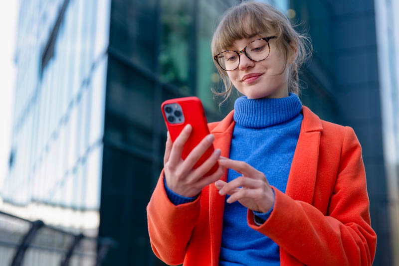 Woman using smartphone outdoors in city.