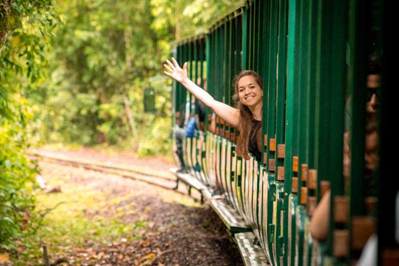 Image of a young woman waving from a departing train.